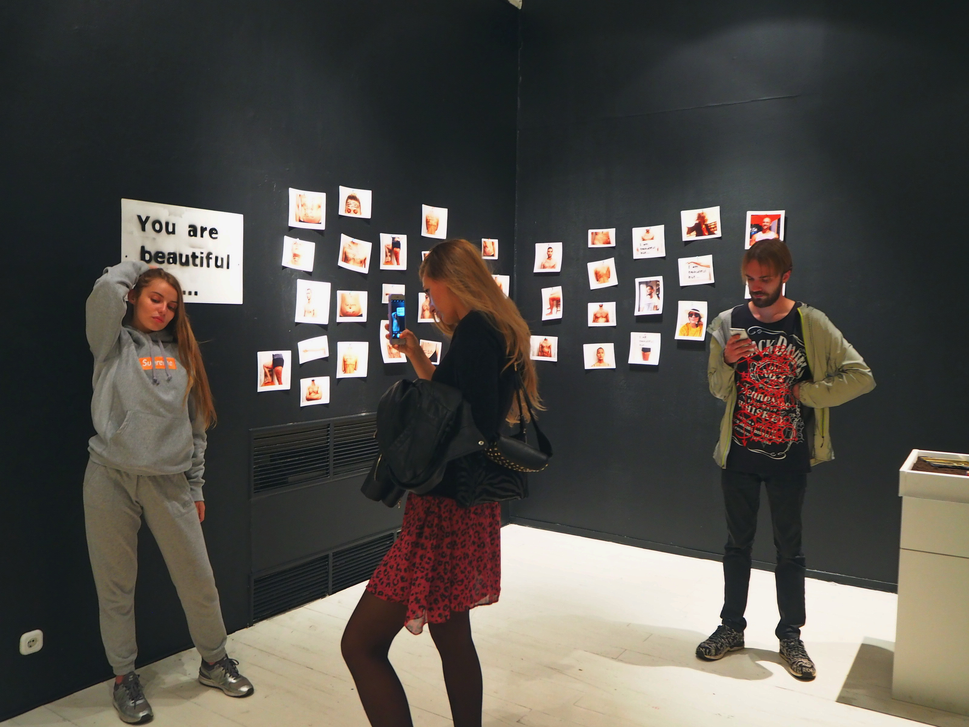 Посетители выставки «Дисморфофобия» на&nbsp;фоне работы Ксении Стрекозы «Я&nbsp;красивая, но…»