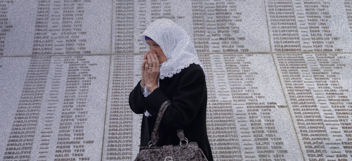 Женщина у мемориальной плиты со списками убитых в Сребренице. Фото: Reuters/Dado Ruvic