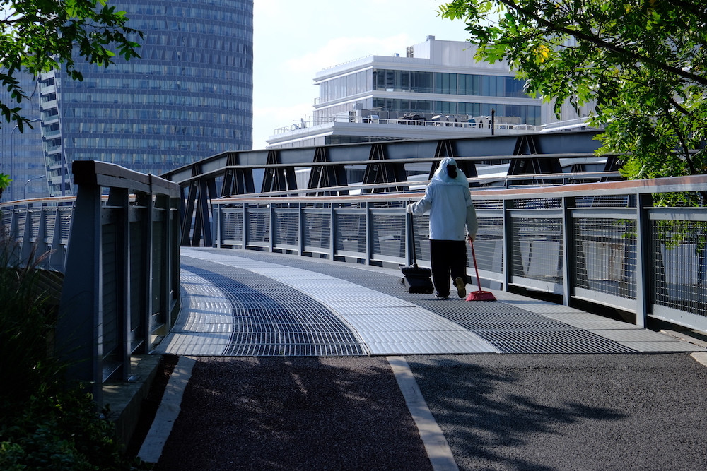 Дворник идет по&nbsp;новому мосту, построенному в&nbsp;рамках проекта по&nbsp;восстановлению городской среды на&nbsp;набережной реки Хуанпу. 18 сентября 2019&nbsp;года. Фотография Никиты Линь