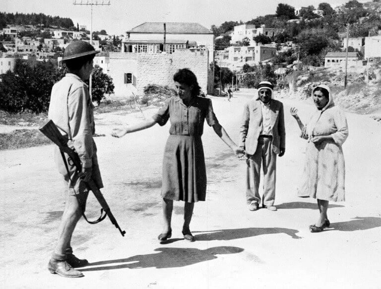 Израильский солдат останавливает палестинцев на одной из улиц Назарета, 1948 г. [AP Photo]