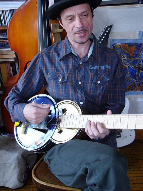 Игорь Титенко играет на&nbsp;жестяной гитаре экспериментальной модели «биплан»