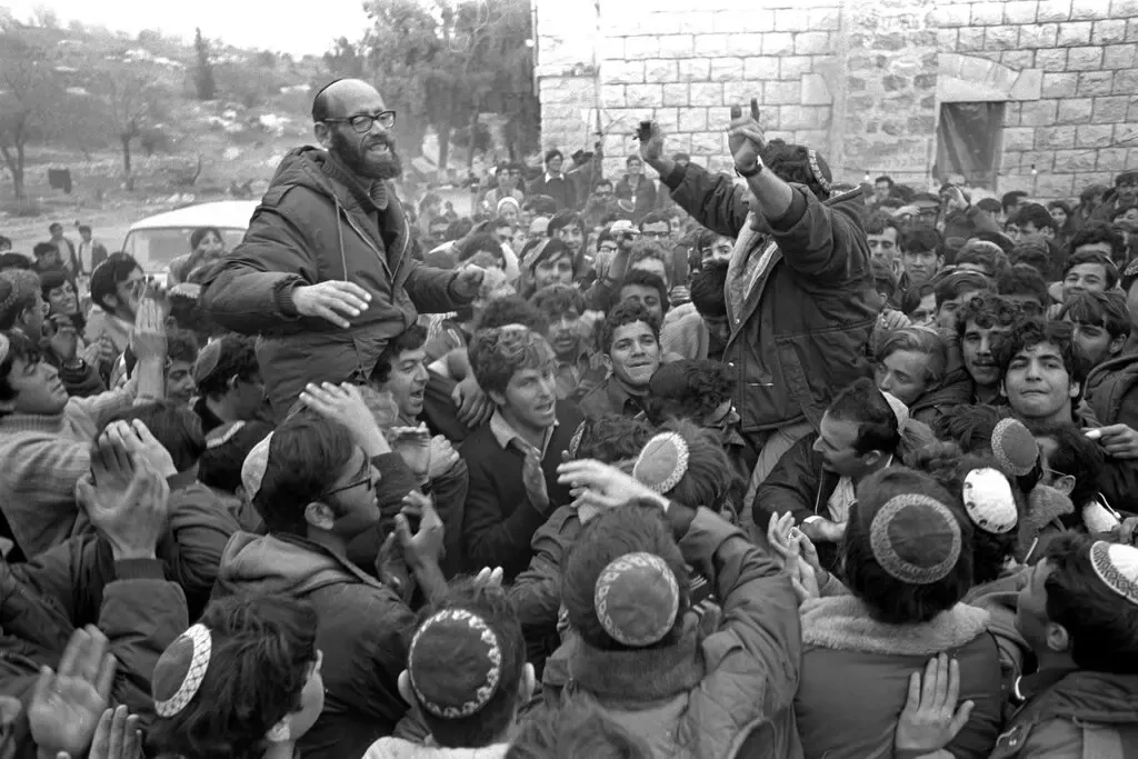 Раввин Моше Левингер (слева) со своими последователями в 1975 году. Будучи одним из лидеров движения «Гуш Эмуним», он озвучил цели этого движения в эфире израильского телевидения. По его словам, арабам «нельзя позволить поднять голову». Фотография: Moshe Milner/GPO через Getty Images