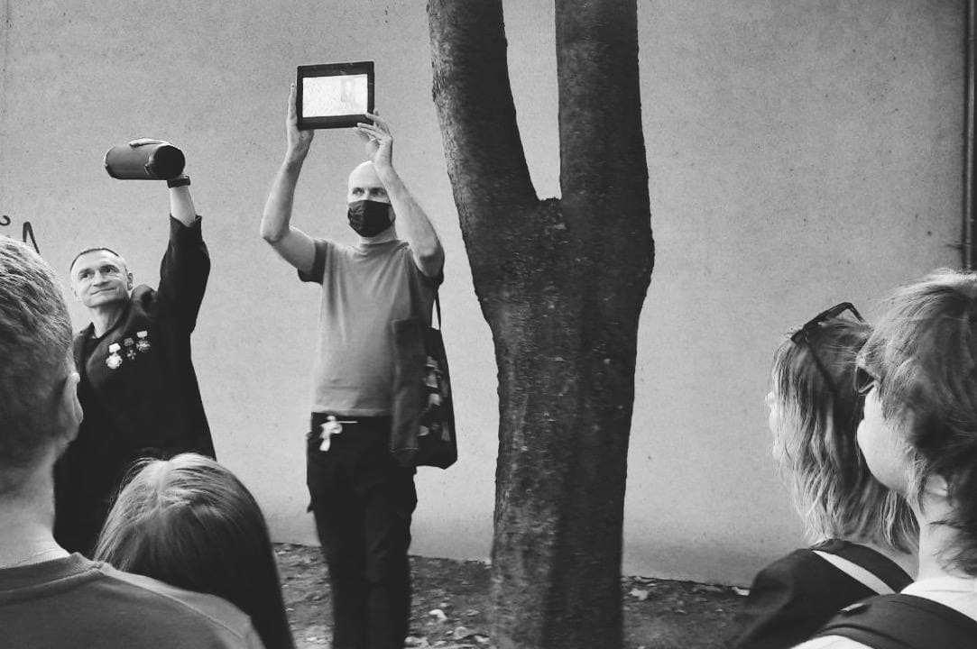 колонка, планшет, режиссёр, актёр спетакля и&nbsp;публика рядом с&nbsp;деревом