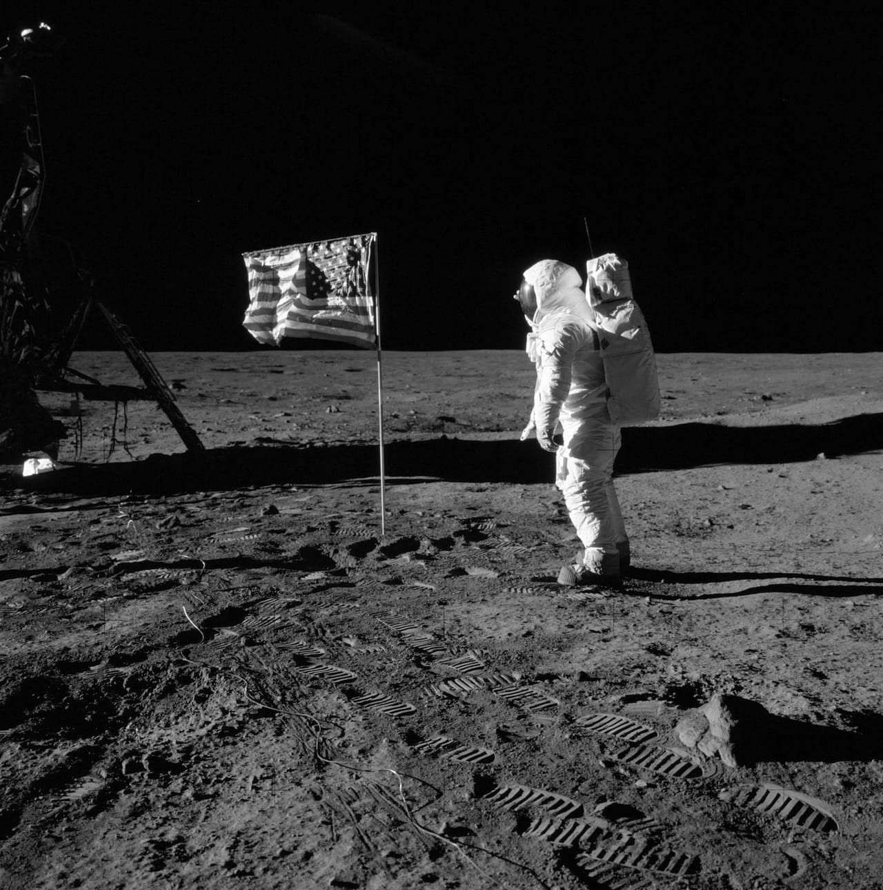 Базз Олдрин приветствует флаг на&nbsp;поверхности Луны, время миссии Аполлона-11: 110: 10: 33. (Кончики пальцев Олдрина видны на&nbsp;дальней стороне его шлема.) Изображение AS11-40-5874, любезно предоставлено НАСА