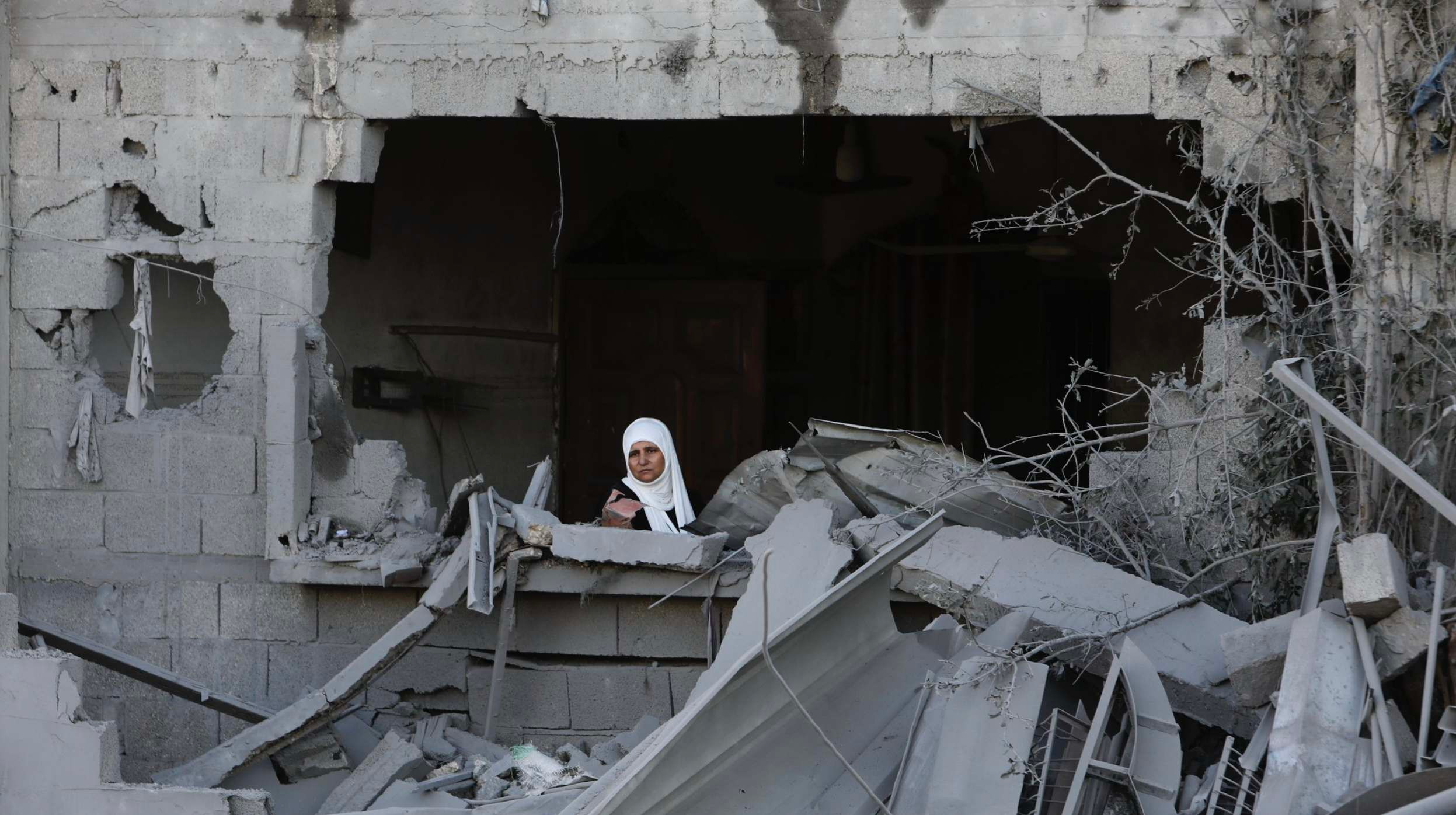 Палестинка дивиться зі свого вікна після ізраїльського удару по сектору Гази, 21 жовтня 2023. Фото: AP