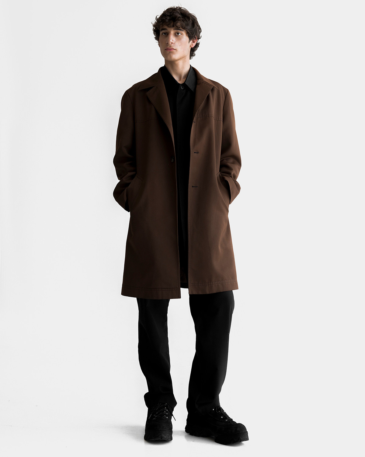 Alex is wearing a sienna cotton PARENT coat, a black satin PARENT jacket and classic NASIR trousers by Ruslan Nasir