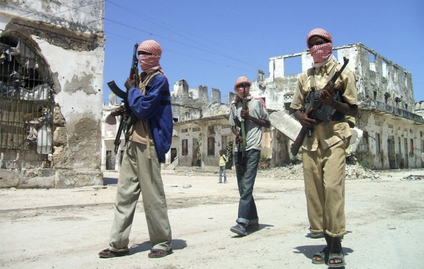Сомалийские исламисты, лояльные переходному федеральному правительству, идут мимо изрешеченных пулями зданий во время патрулирования северной части Могадишо, 26 мая 2009 (REUTERS/ Ismail Taxta (SOMALIA CONFLICT SOCIETY)